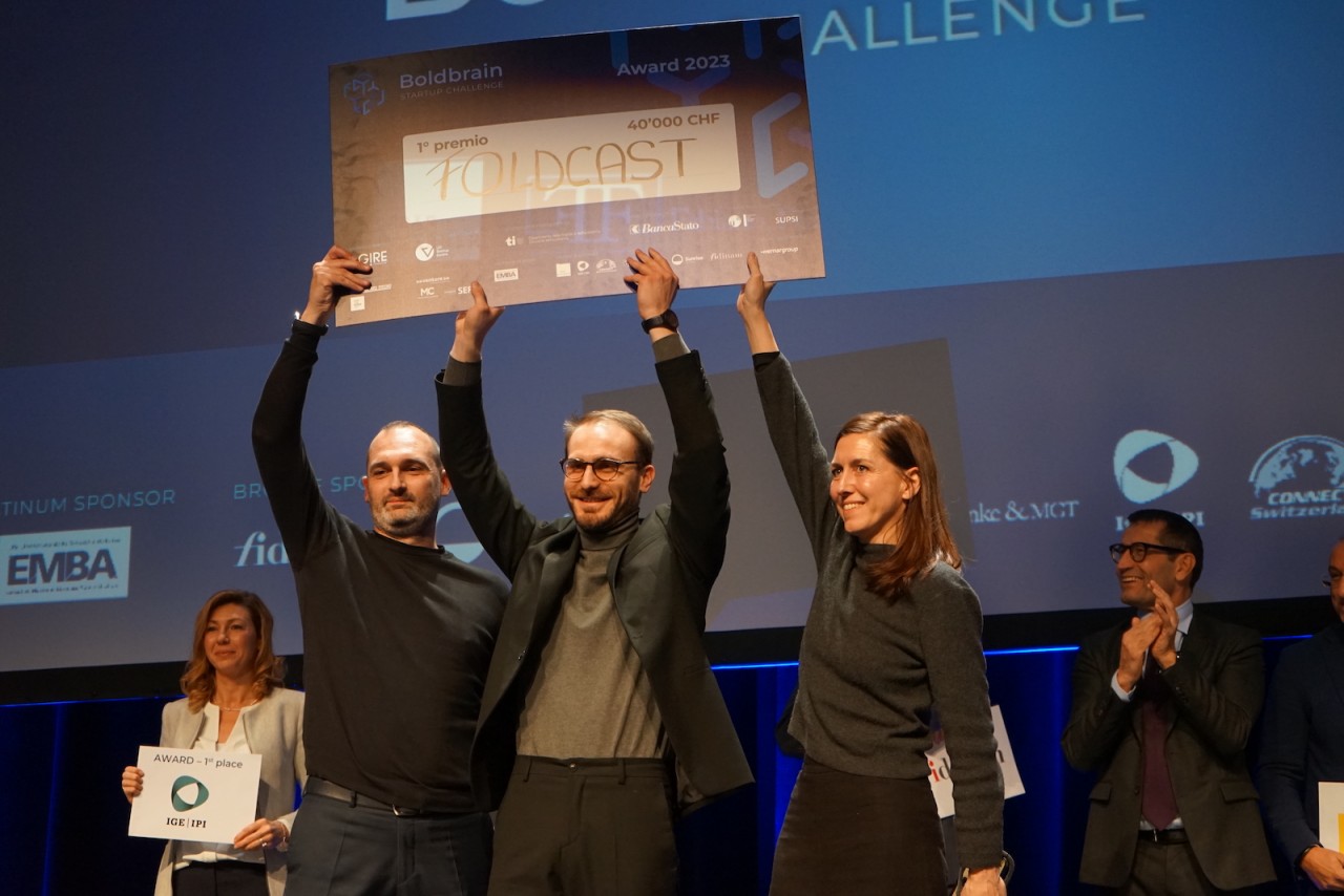 I cofondatore di "Foldcast" (da sinistra, Andrea Realini, Fabio Amicarelli e Ena Lloret-Fritschi) sollevano l’"attestato" del primo premio (foto di Eugenio Celesti)